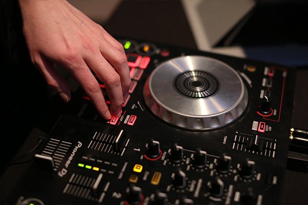 Hand above a DJ mixer.