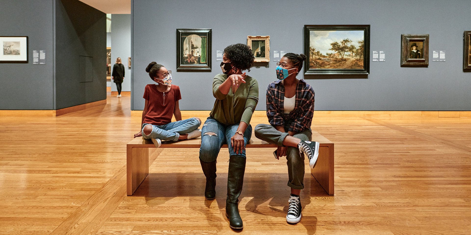 A young family sits in a gallery.